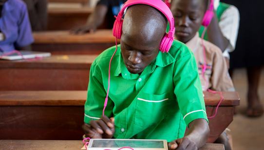 Boy with pink headphones receiving quality education in a class with Can't Wait to Learn Uganda_War Child_180606