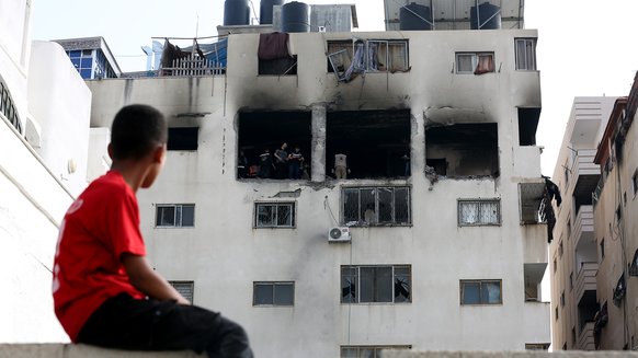 A child in Gaza looking at his bombed home