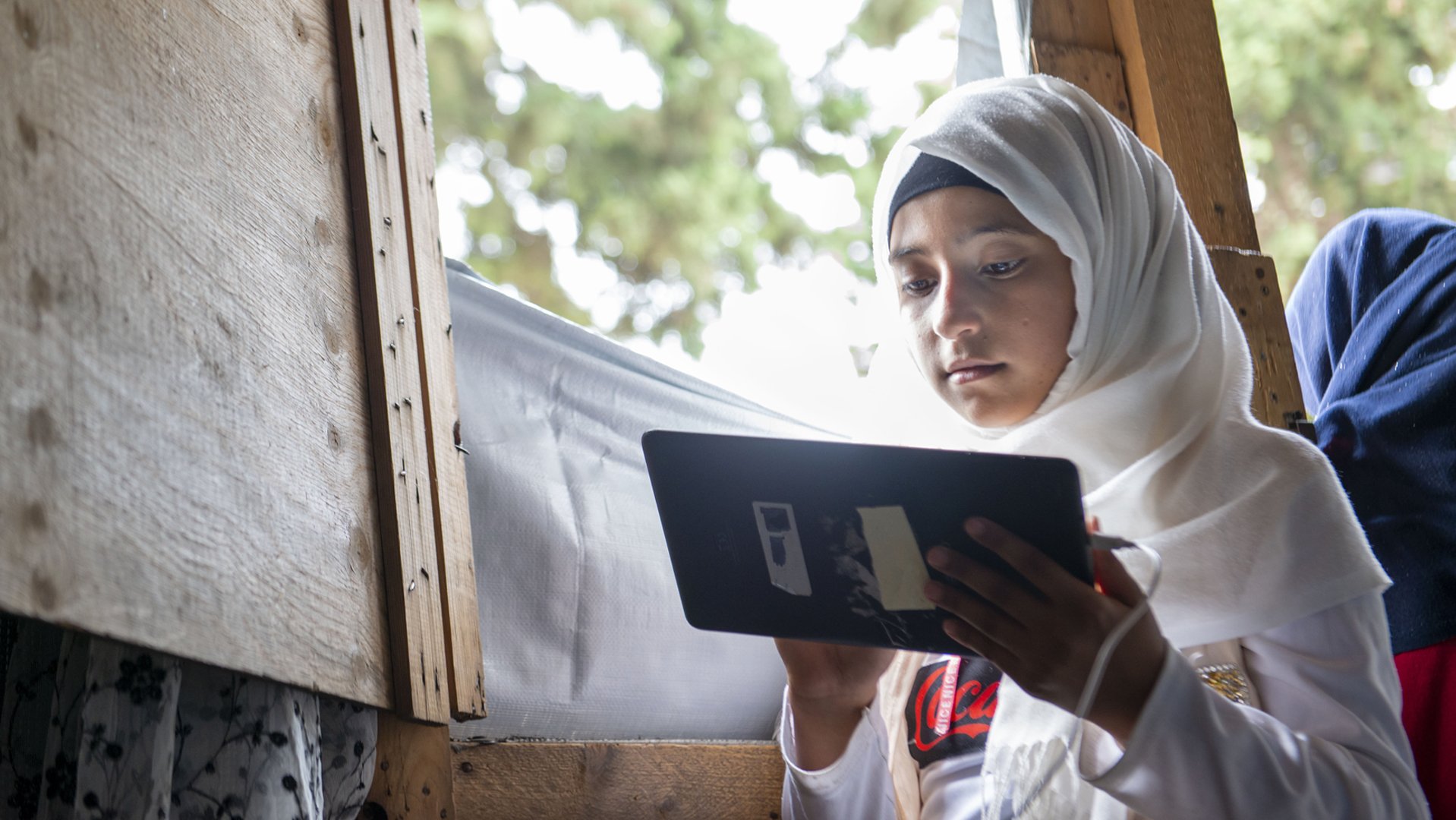 Kinderen leren in Libanon via War Child's Can't Wait to Learn op tablets - meisje bij raam