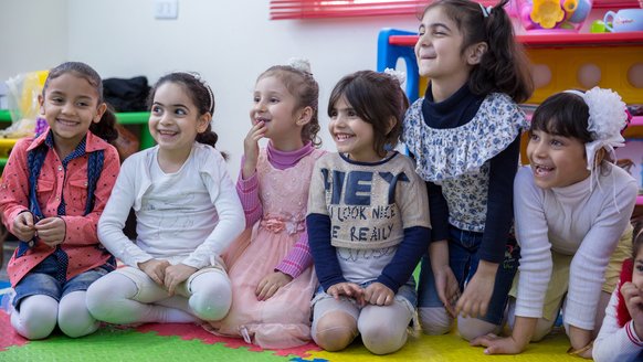 Meisjes lachend in kleuterklas in Jordanie - War Child